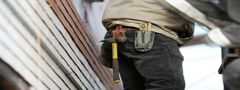 Carpinteiro medindo e cortando madeira